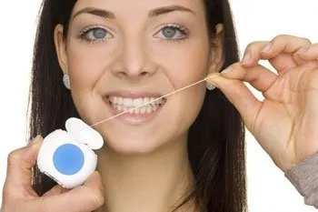 a woman flossing teeth