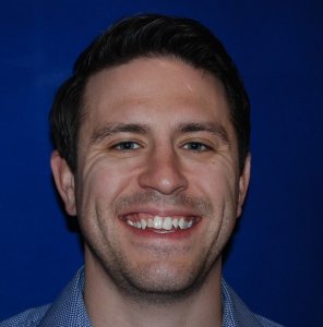 Man smiling with crooked teeth before Invisalign treatment.